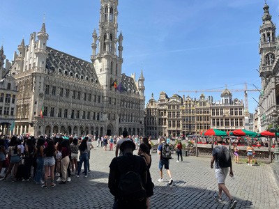 Touristen auf dem Grand Place in Brüssel bei sonnigem Wetter Menschen versammeln sich auf dem Grand Place in Brüssel an einem sonnigen Tag, umgeben von historischen Gebäuden.